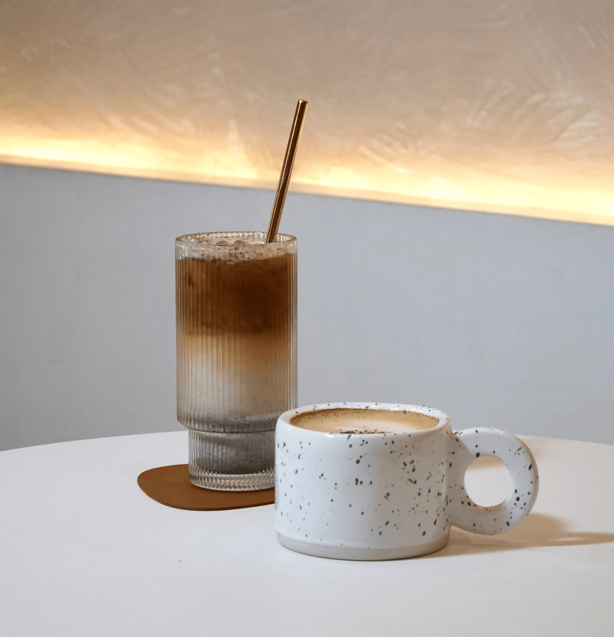 Iced latte and hot coffee in the softly lit café